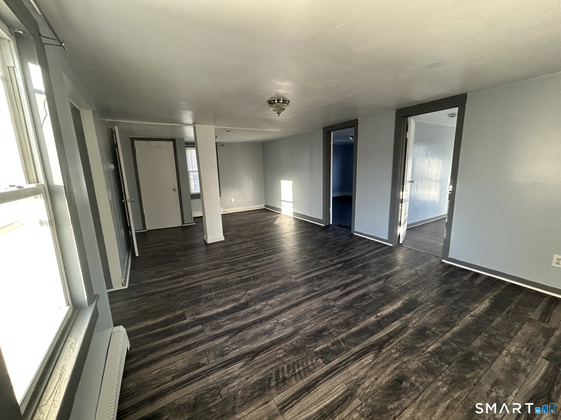 288 Litchfield Street, Unit 2 Torrington, CT 06790 - Photo 5 of 15 a view of an empty room with wooden floor and a window