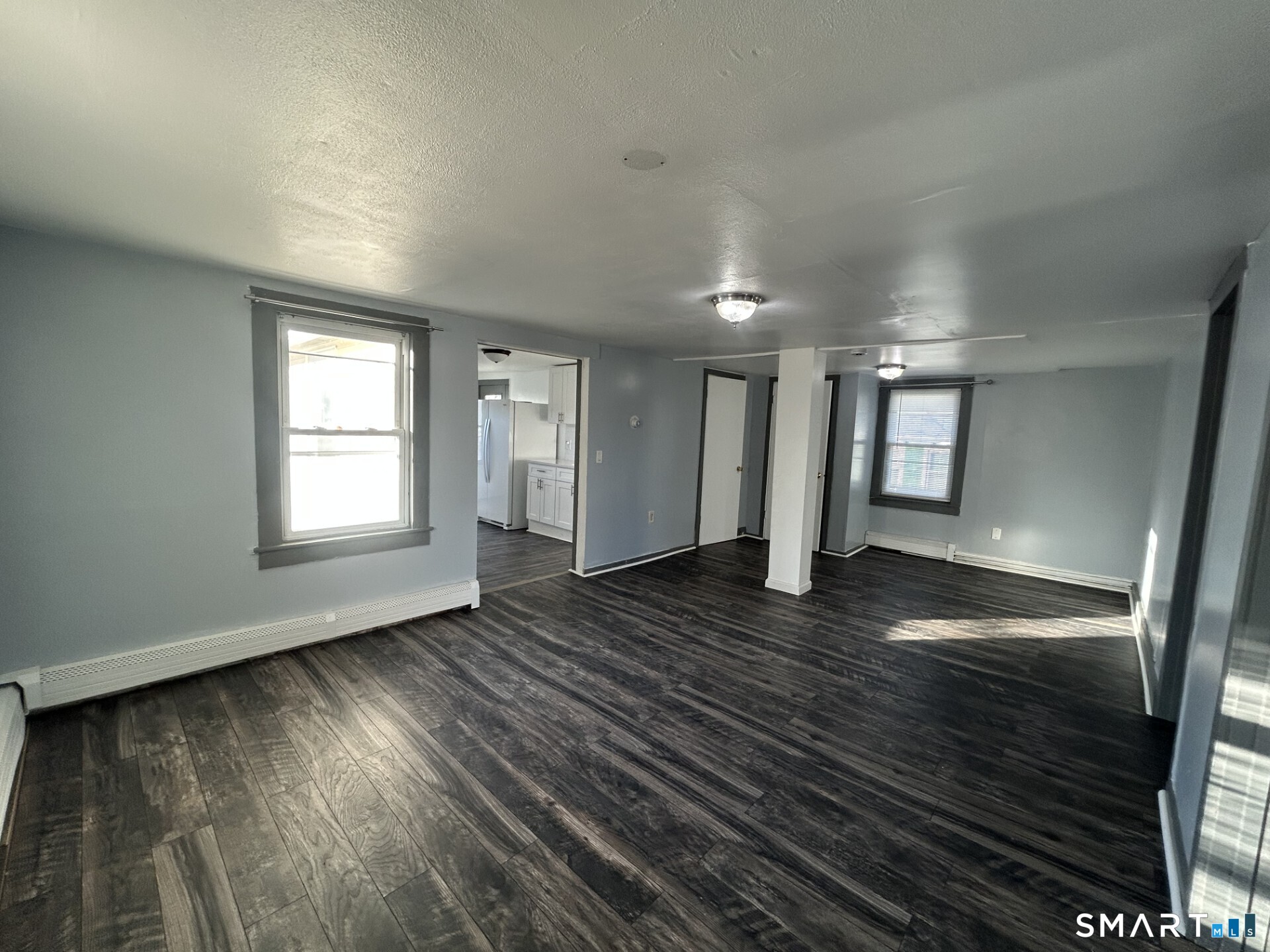 288 Litchfield Street, Unit 2 Torrington, CT 06790 - Photo 7 of 15 an empty room with wooden floor and windows