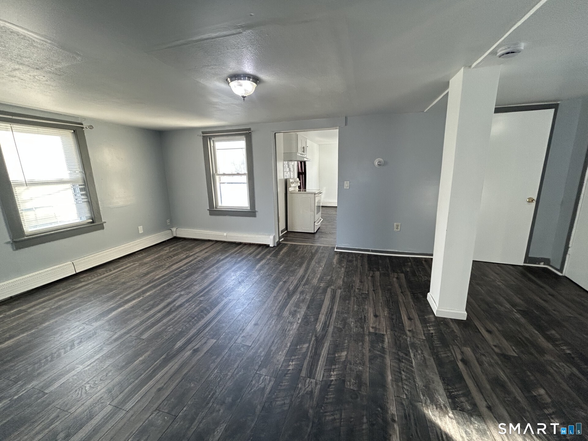 288 Litchfield Street, Unit 2 Torrington, CT 06790 - Photo 8 of 15 an empty room with wooden floor and windows