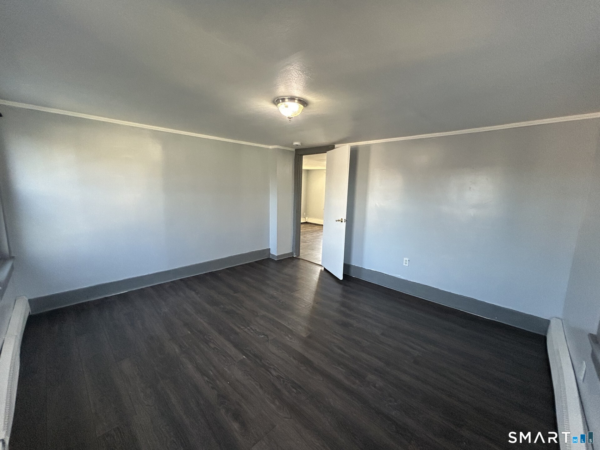 288 Litchfield Street, Unit 2 Torrington, CT 06790 - Photo 9 of 15 an empty room with wooden floor and windows