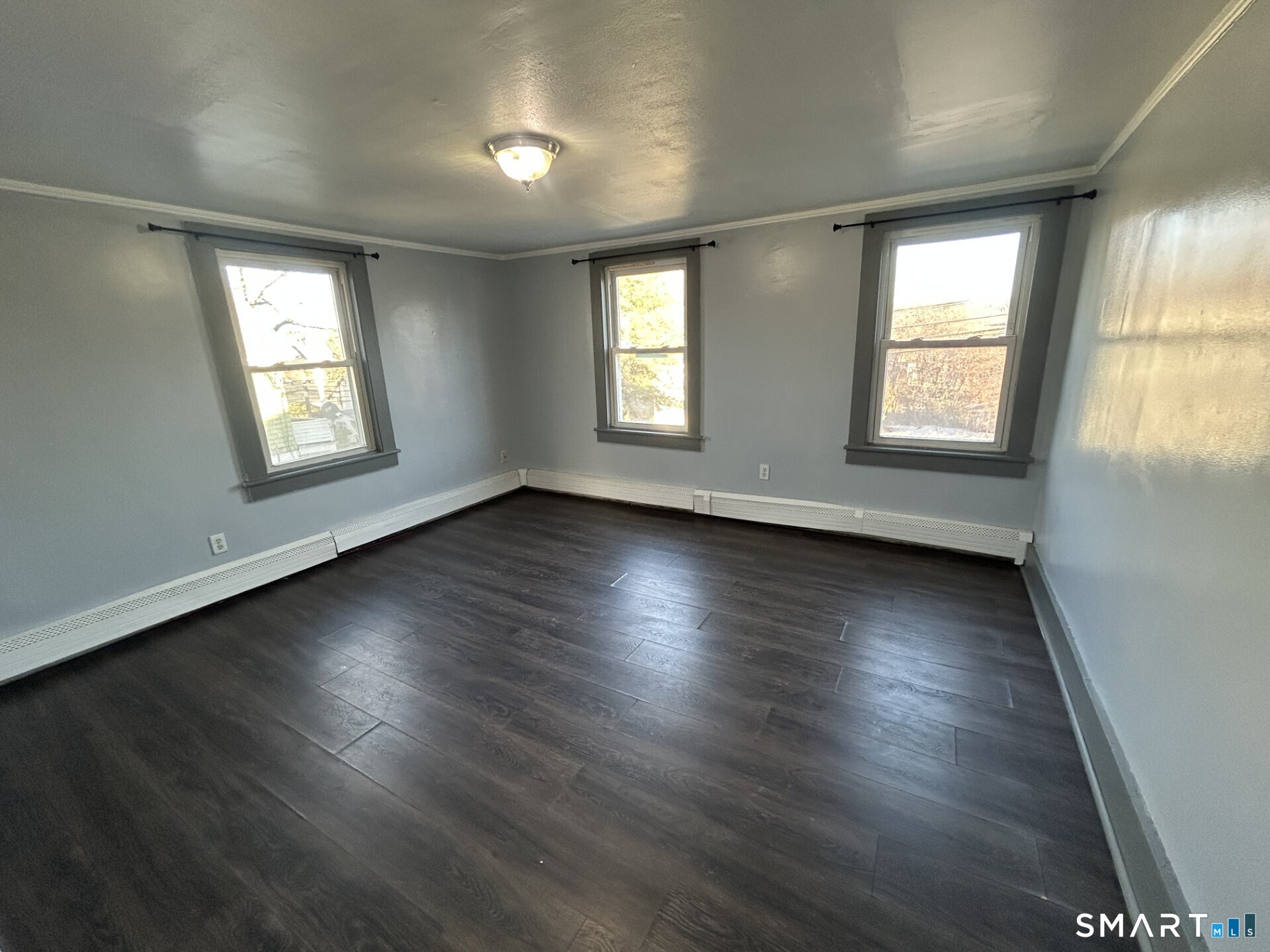 288 Litchfield Street, Unit 2 Torrington, CT 06790 - Photo 10 of 15 an empty room with wooden floor and windows