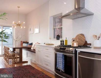 a kitchen with a sink a stove and chairs