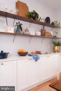 a kitchen with white cabinets and a wooden floor