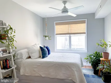 a bedroom with a bed and a potted plant