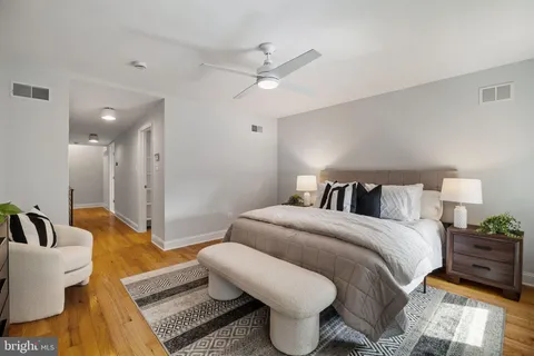 a spacious bedroom with a bed and ceiling fan