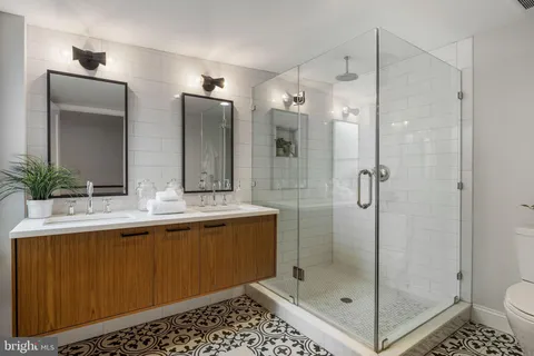 a bathroom with a shower sink mirror and toilet
