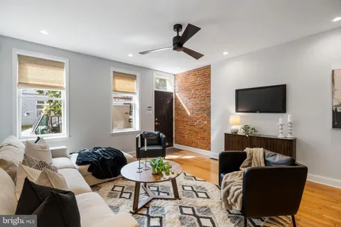 a living room with furniture a flat screen tv and a large window