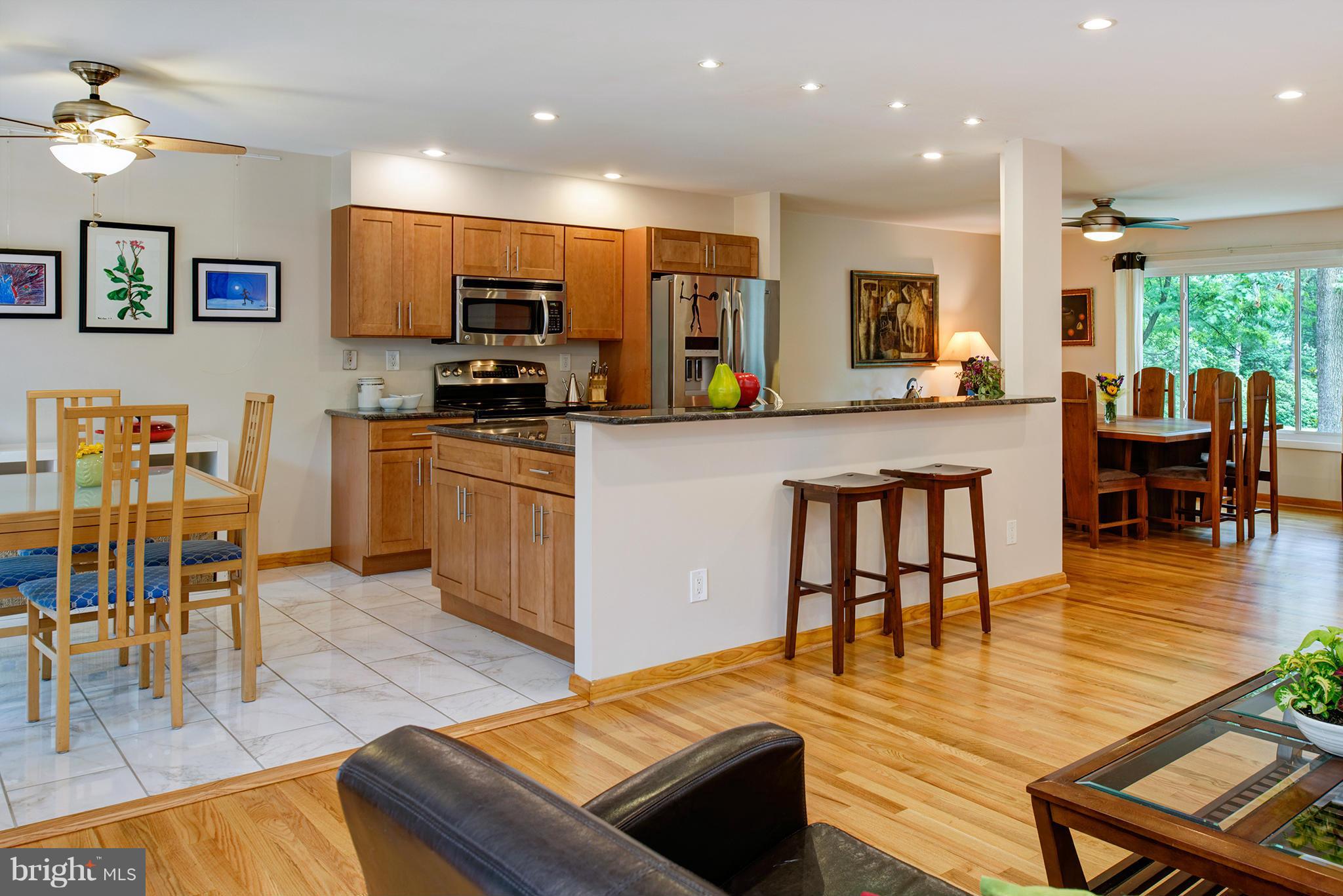 2407 Myrtle Lane Reston, VA 20191 - Photo 11 of 28 a kitchen with stainless steel appliances granite countertop a stove top oven a sink a dining table and chairs with wooden floor
