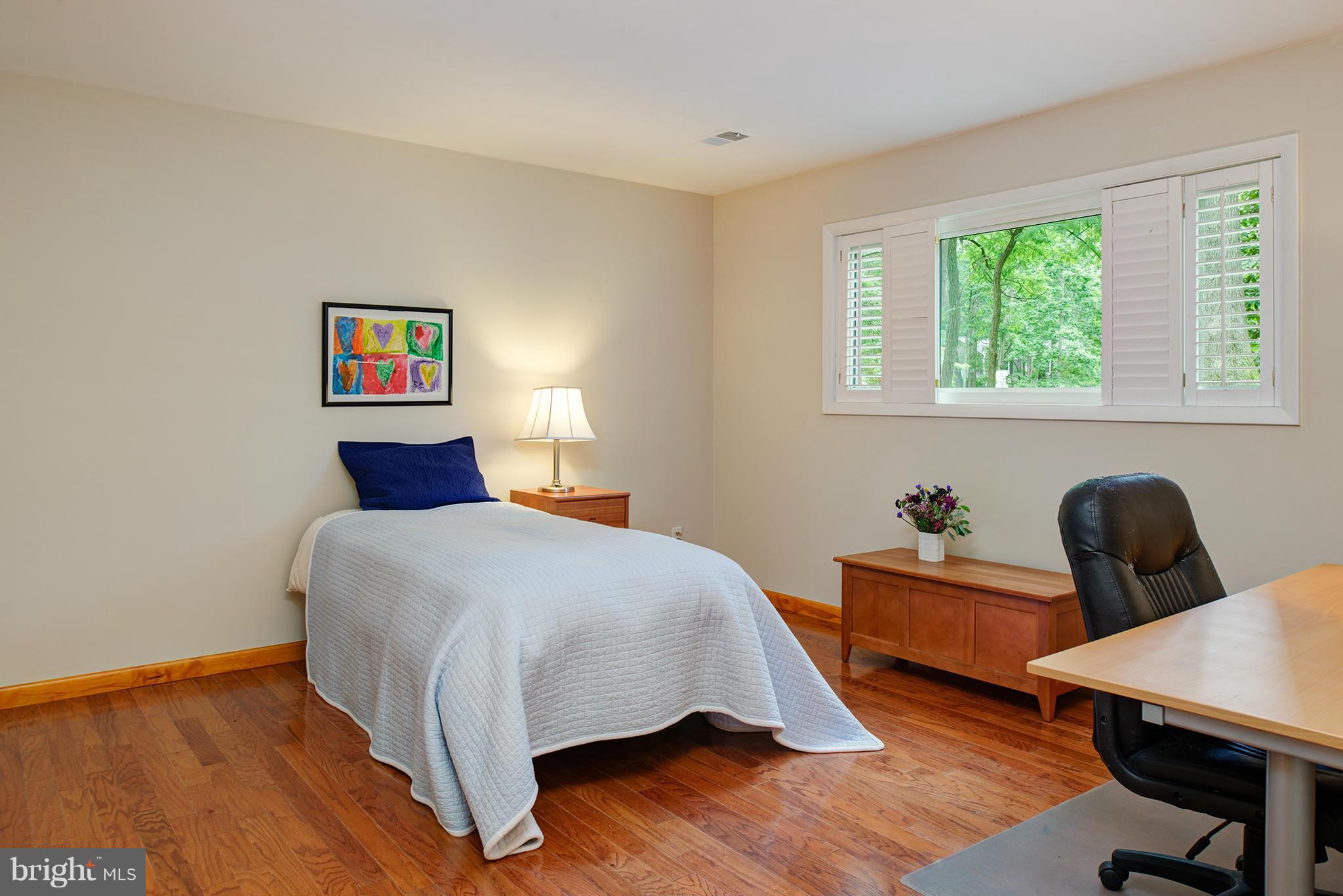 2407 Myrtle Lane Reston, VA 20191 - Photo 17 of 28 a bedroom with a bed a desk and chair with wooden floor