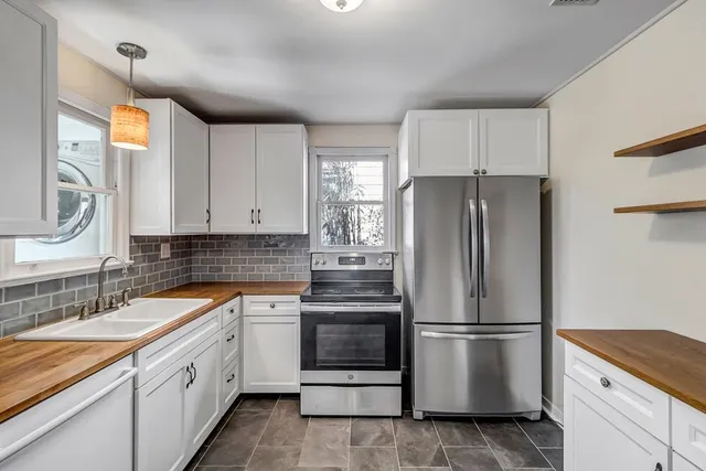 a kitchen with white cabinets and white appliances