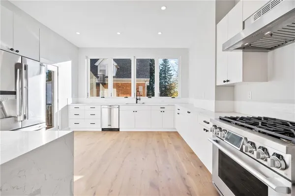 a kitchen with granite countertop a stove a sink and a refrigerator