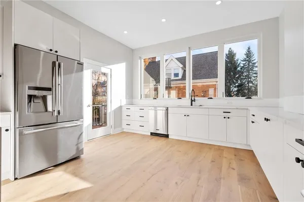 a kitchen with stainless steel appliances a refrigerator sink and cabinets