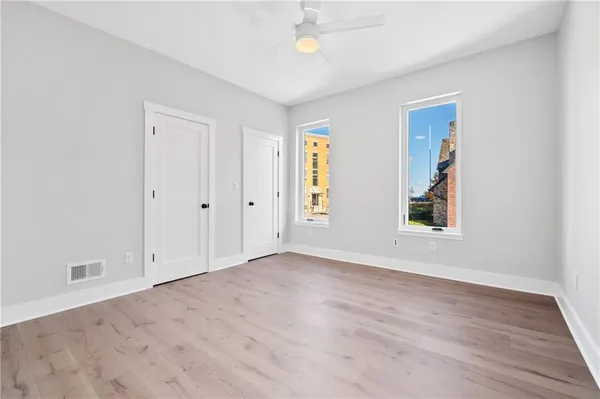 an empty room with wooden floor and windows