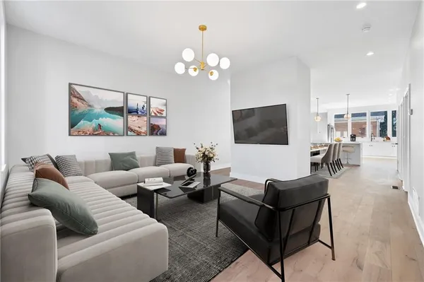 a living room with furniture a chandelier and a flat screen tv