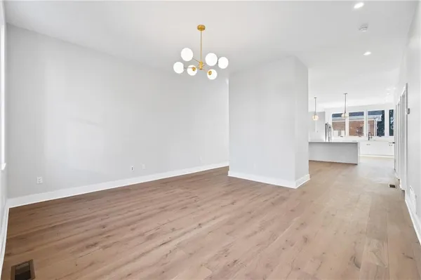 a view of a room with wooden floor and chandelier