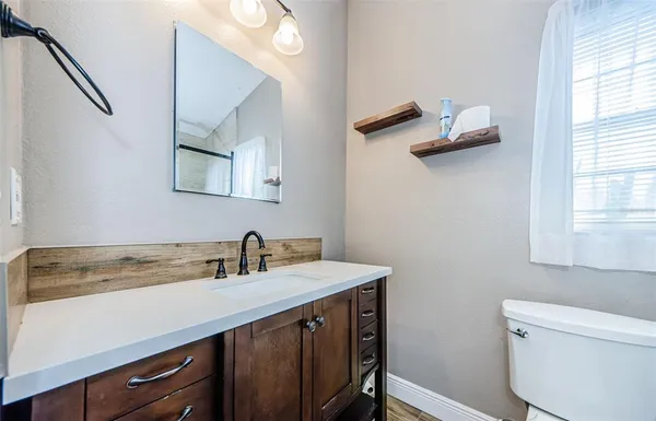 a bathroom with a sink a mirror and a toilet