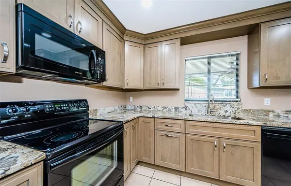 a kitchen with stainless steel appliances a stove sink microwave and cabinets