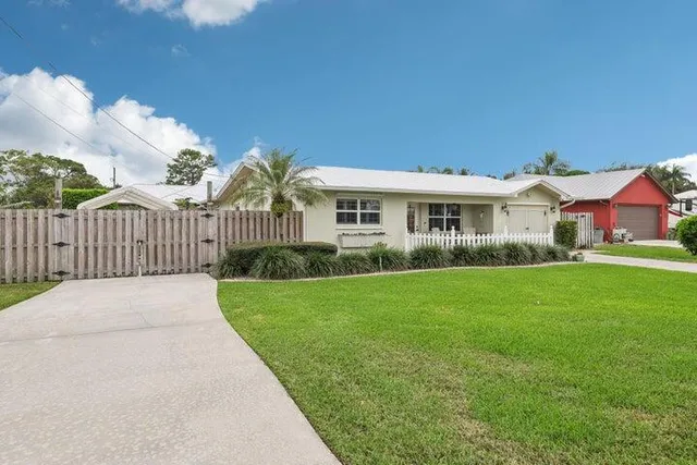 a view of a house with a big yard plants and large trees