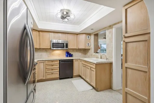 a kitchen with stainless steel appliances granite countertop a refrigerator sink and stove