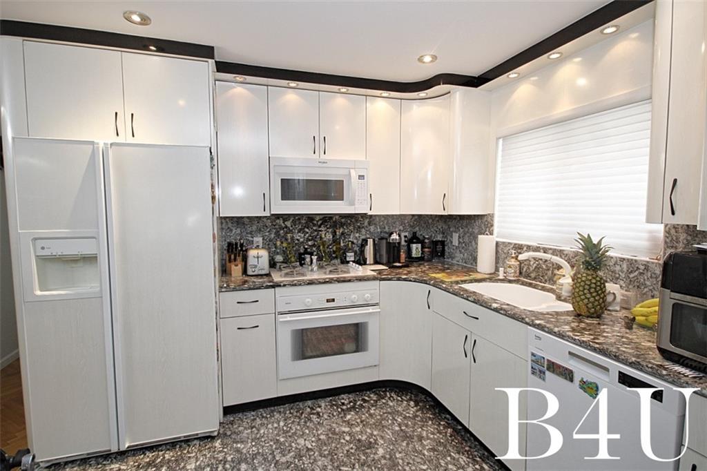 2268 56th Drive Brooklyn, NY 11234 - Photo 9 of 20 a kitchen with granite countertop white cabinets and white appliances