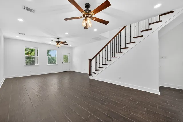 wooden floor in an empty room with a ceiling fan