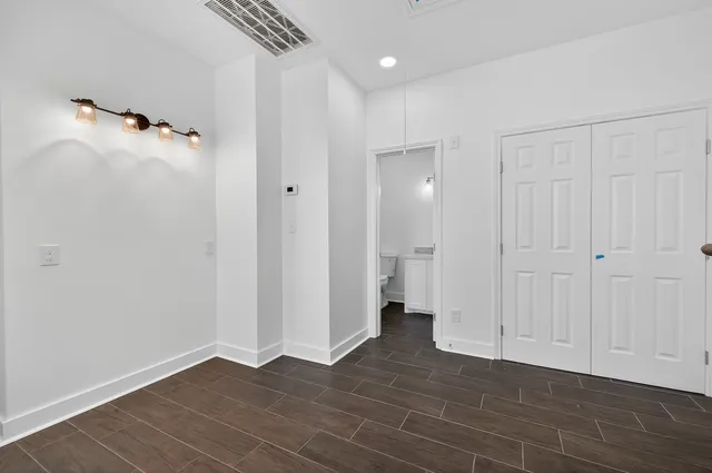 an empty room with closet and a ceiling fan