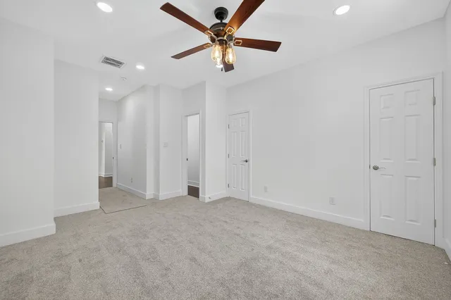 an empty room with a window and a ceiling fan