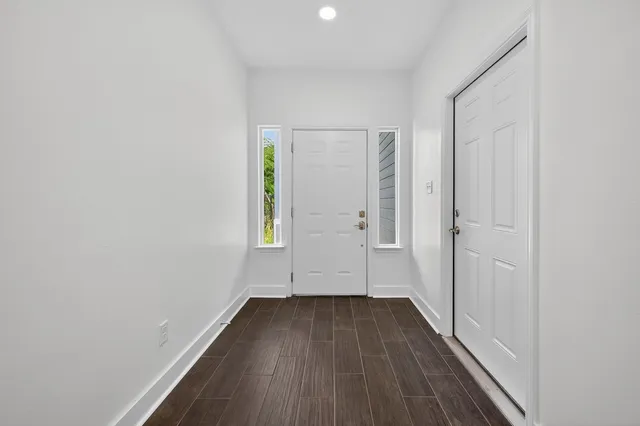 a view of a small space with wooden floor and a window