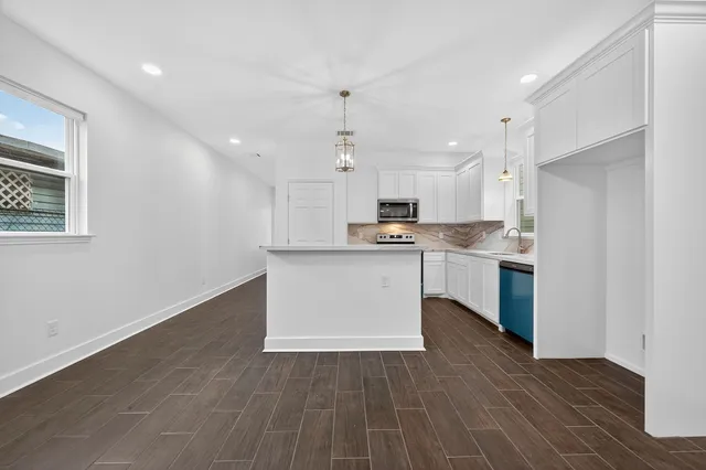 a large kitchen with kitchen island a sink stainless steel appliances and cabinets