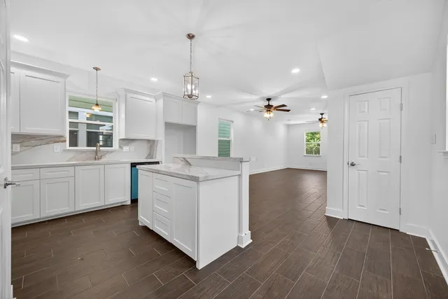 a bathroom with a granite countertop toilet sink and mirror