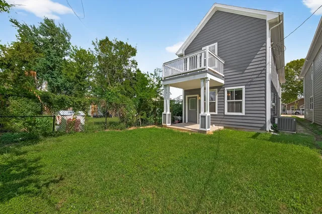 an empty room with wooden floor and staircase