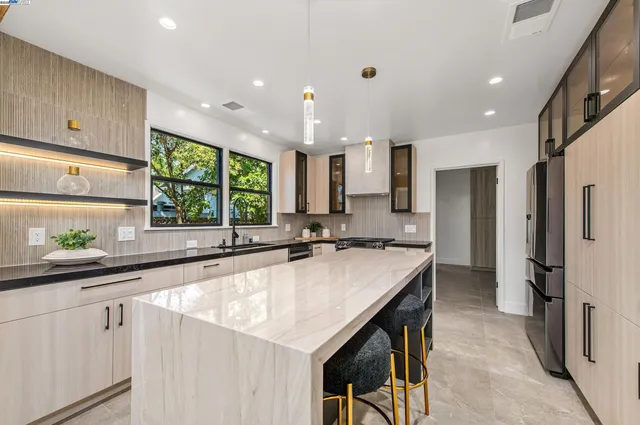 a kitchen with counter top space a sink stainless steel appliances and windows
