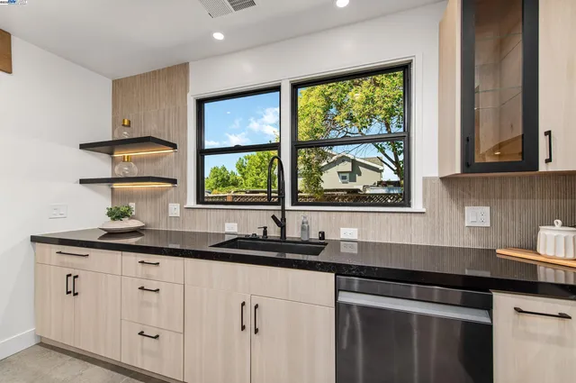 a kitchen with stainless steel appliances white cabinets and a large window