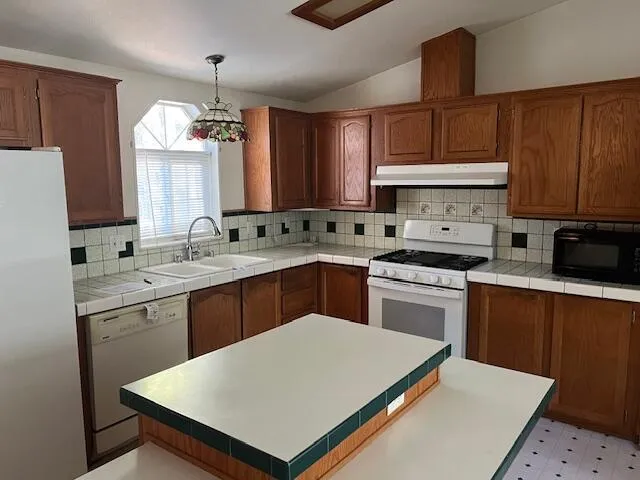 a kitchen with a sink a stove a refrigerator and cabinets