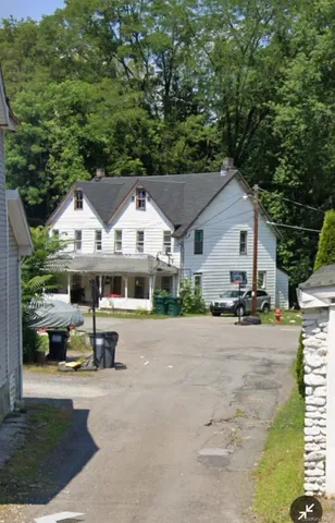 a view of house with outdoor space and parking