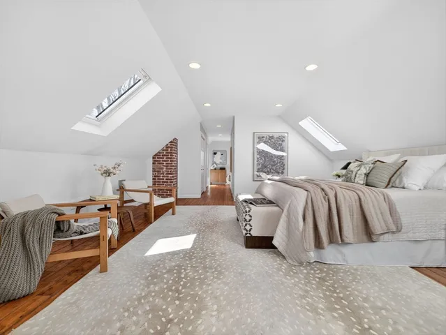 a spacious bedroom with a bed and wooden floor