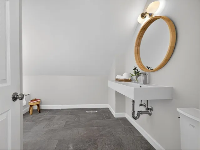 a bathroom with a toilet a sink and mirror