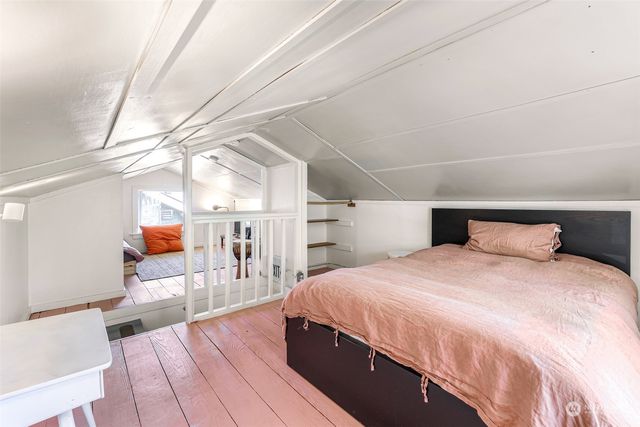 a bedroom with a large bed and wooden floor