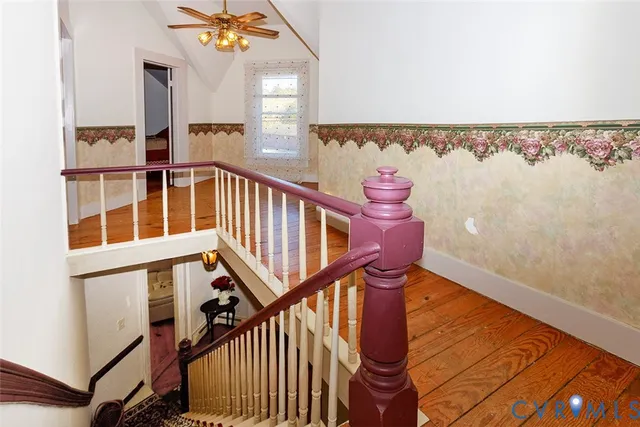 a view of staircase with railing and white walls
