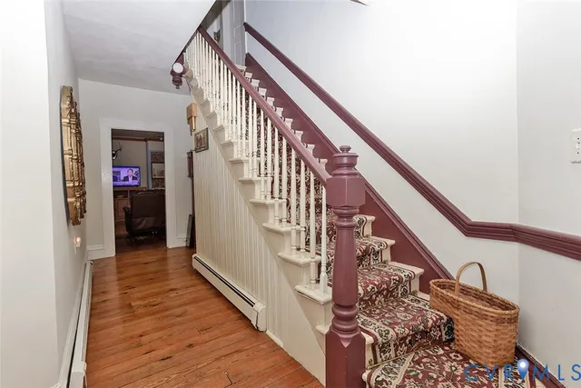 a view of a hallway with wooden floor and staircase