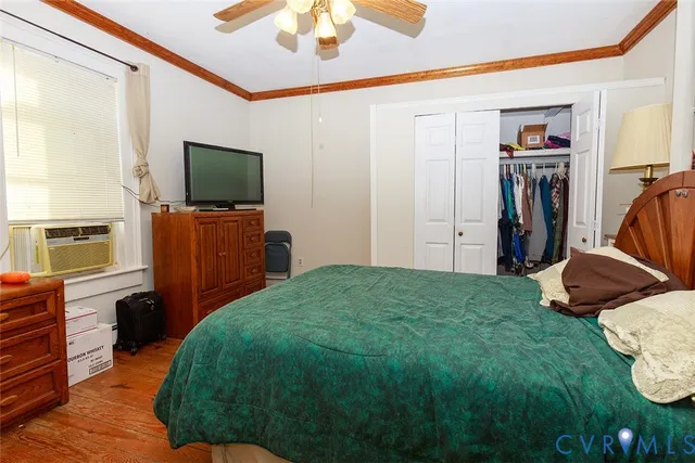 a bedroom with a bed and a flat tv screen on dresser