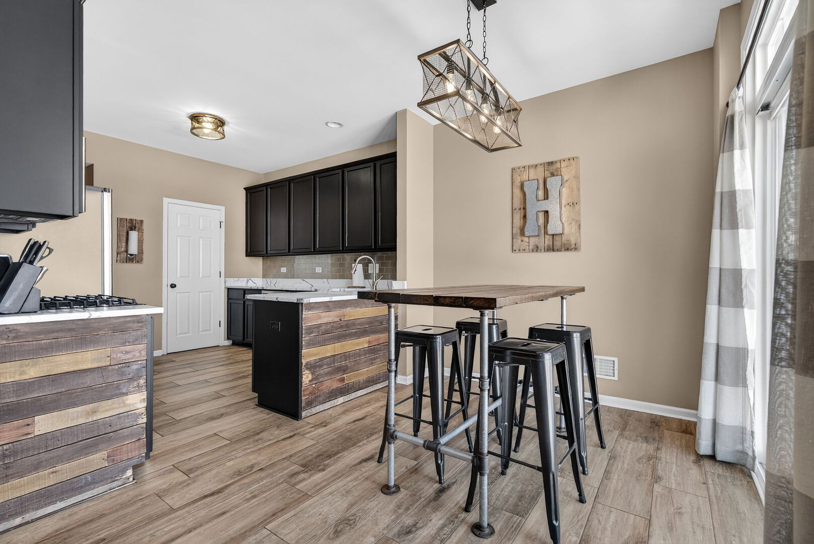15238 Kenmare Circle Manhattan, IL 60442 - Photo 6 of 29 a kitchen with a table chairs refrigerator and cabinets