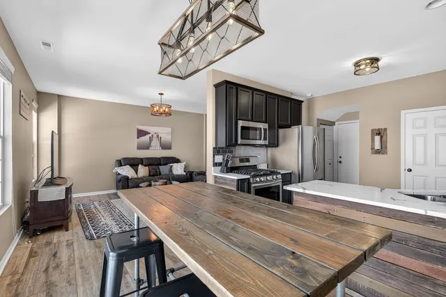 a living room with furniture a flat screen tv and kitchen view