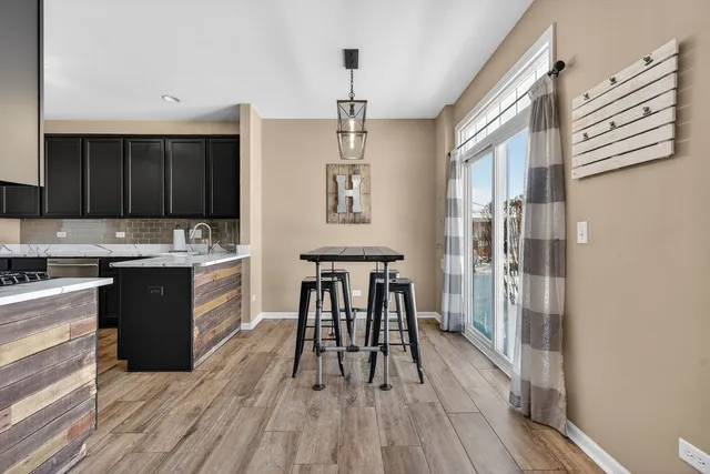 a kitchen with a table chairs refrigerator and cabinets