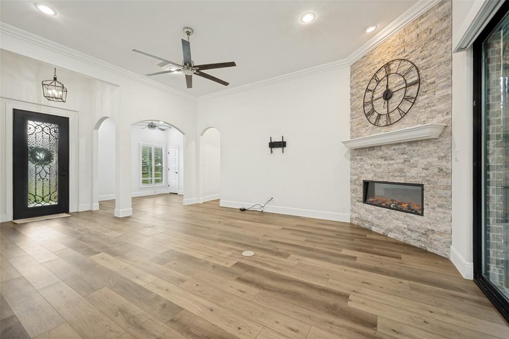444 Ben Boyd Road Argyle, TX 76226 - Photo 5 of 28 a view of a livingroom with a fireplace a ceiling fan and windows
