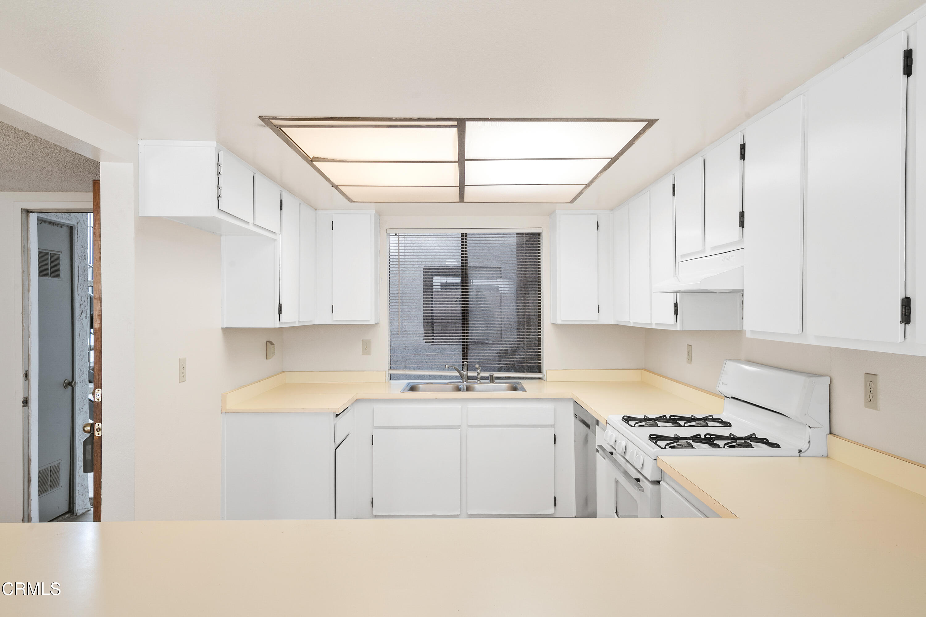 5202 Longfellow Way Oxnard, CA 93033 - Photo 7 of 21 a kitchen with kitchen island white cabinets and white appliances