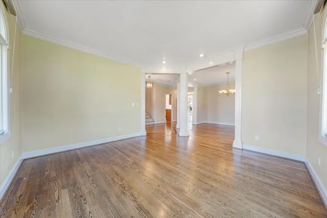 a view of a room with wooden floor chandelier and a window