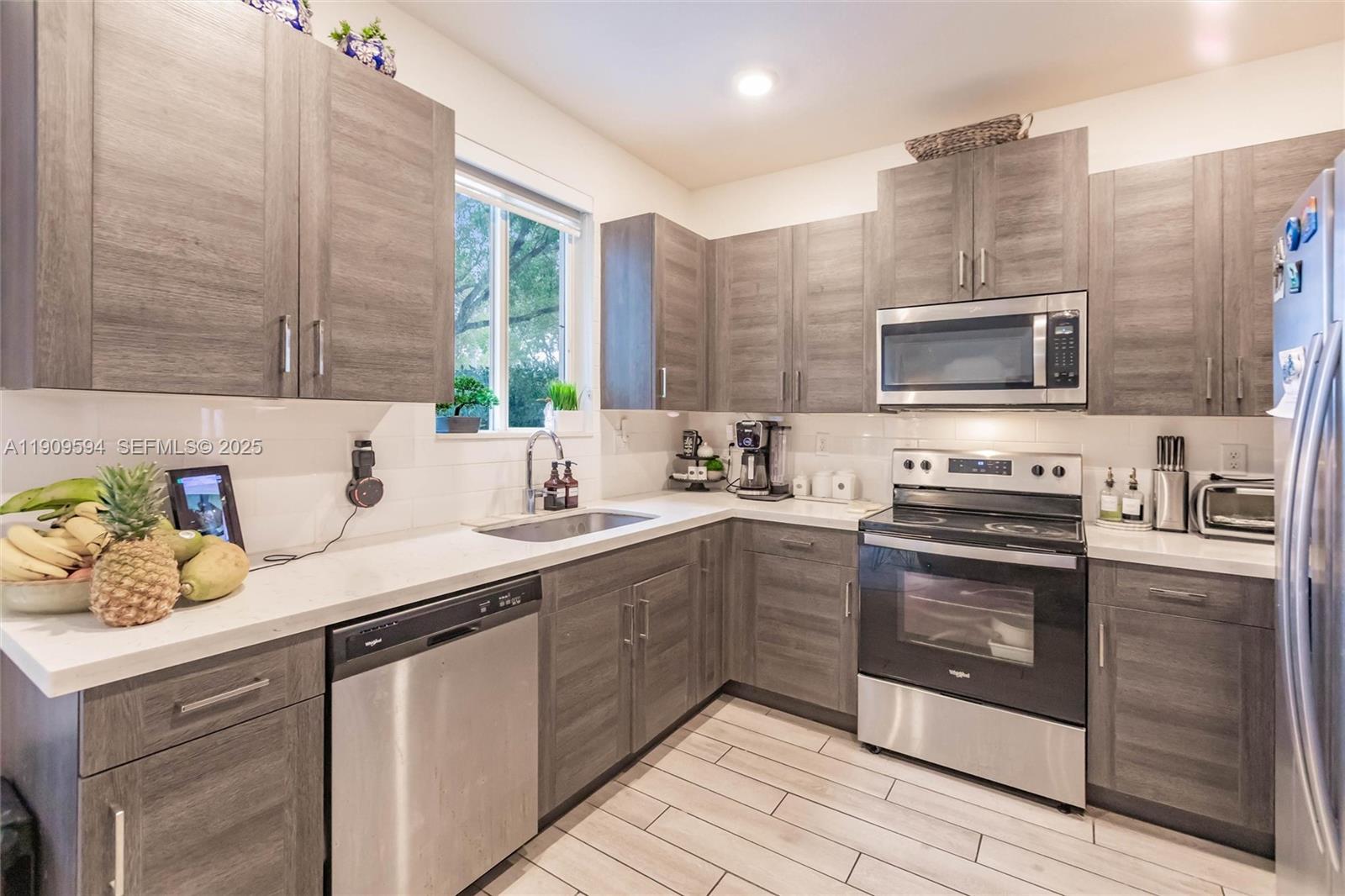2333 Southeast 10th Street Homestead, FL 33035 - Photo 5 of 22 a kitchen with stainless steel appliances a stove sink and cabinets