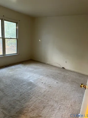 an empty room with windows and closet