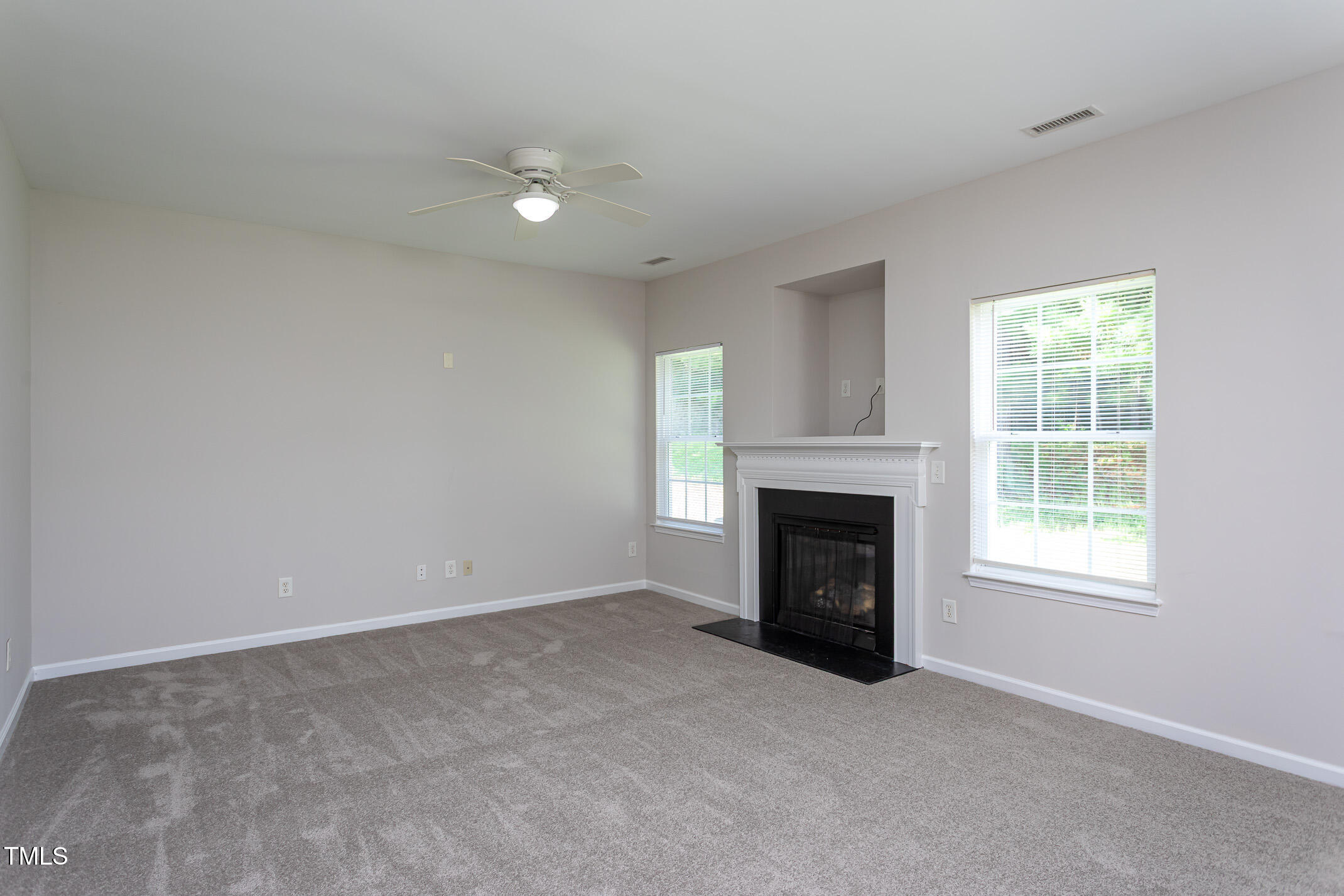601 Weeping Willow Drive Durham, NC 27704 - Photo 10 of 36 an empty room with fireplace and windows